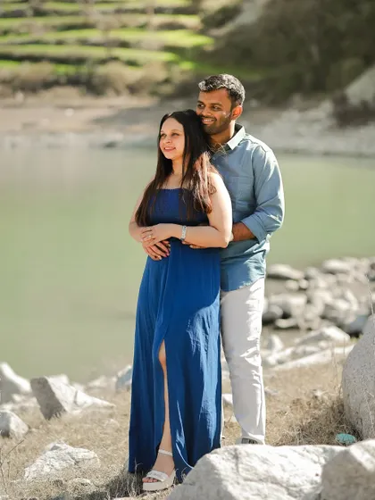 A serene shot of a couple by the water in Dalhousie, enjoying the calm and beautiful scenery.