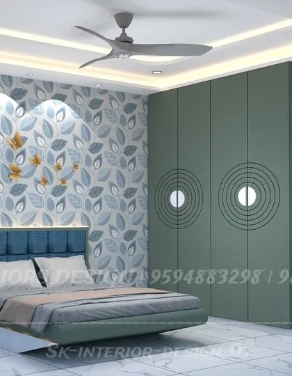 A vibrant bedroom design with sage green wardrobes featuring unique circular grooves. The floral wallpaper behind the bed adds a touch of nature and personality.