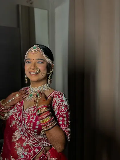 A beautiful portrait of the bride, looking away with a gentle smile. The soft lighting highlights her glowing skin and intricate jewellery.