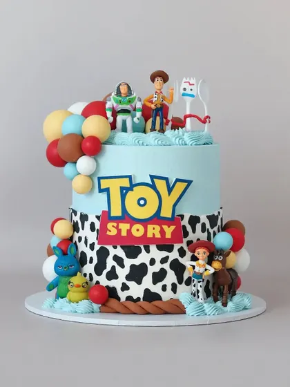 To infinity and beyond! This Toy Story cake is packed with fun details, including the iconic cow print, a balloon garland, and beloved characters like Woody and Buzz Lightyear.