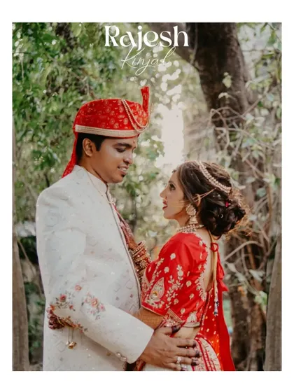 A classic portrait of the couple in a wooded setting. The image captures their elegant red and white attire and the loving way they look at each other.