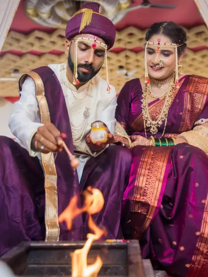 The couple makes an offering to the sacred fire, a central and symbolic part of their Hindu wedding ceremony.