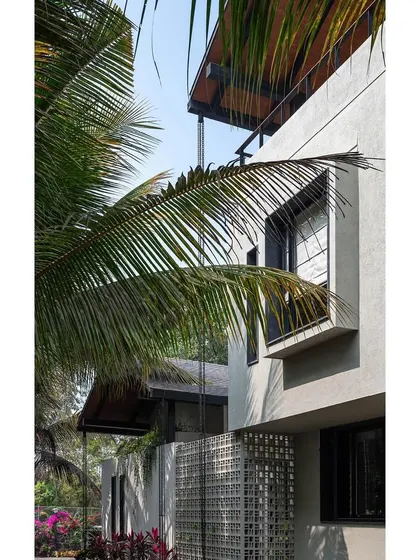 A view of the Grove House facade through the palm trees, capturing the essence of this tropical retreat.