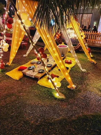 This view shows the low seating arrangement with a mix of yellow mats and red cushions. It's a comfortable and informal way for guests to gather and enjoy a special meal together.