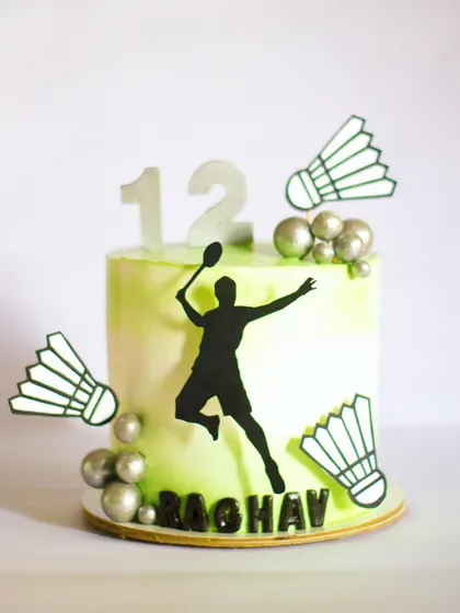 A birthday cake for a little badminton champ! The silhouette of the player and the shuttlecocks are hand-cut from paper, and the watercolor effect on the frosting gives it a dynamic, sporty feel.