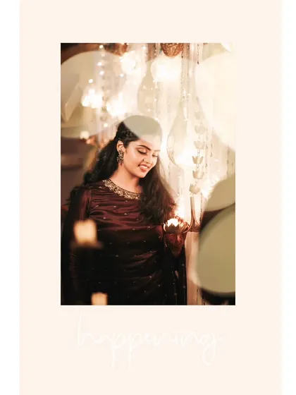 A beautiful, candid portrait of the bride at her reception, her face illuminated by the warm glow of candles.