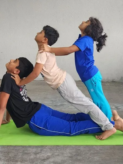 A three-person assisted cobra pose, creating a beautiful cascading effect of arches and support.
