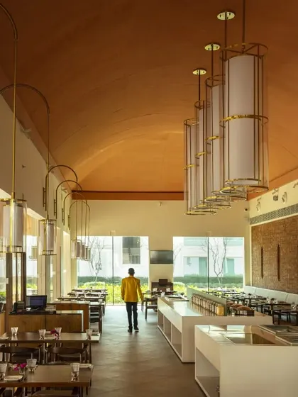 The hotel's cafe, where high, vaulted terracotta ceilings and large windows create an airy, light-filled dining space that feels both expansive and welcoming.