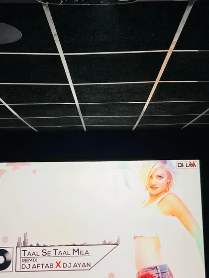 A home theater is not just for movies. Here you can see the high-resolution screen being used for music playback, with the grid-style acoustic ceiling treatment visible above.
