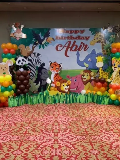 A classic jungle animal theme for Abir's birthday, with a large backdrop and balloon columns featuring various animals like giraffes, monkeys, and elephants.