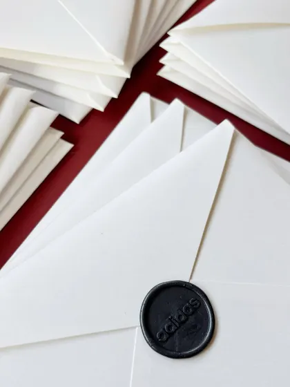 The finishing touches for the Adidas project. Each personalized certificate was enclosed in a subtly textured white envelope, carefully addressed with a brush pen, and sealed with a dark grey custom Adidas wax seal.