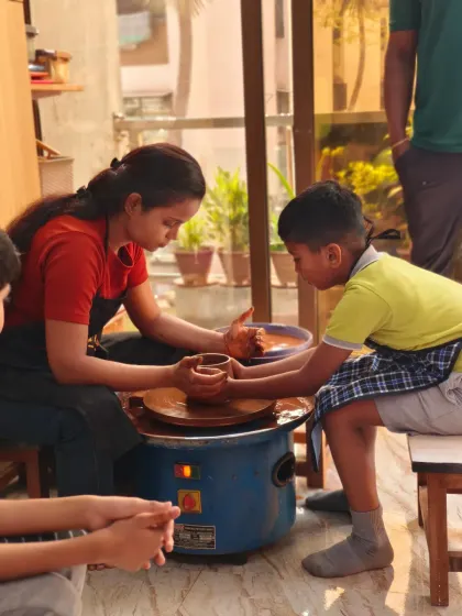 An instructor provides gentle, hands-on guidance to a young student at the pottery wheel. We believe art is for everyone, and our studio is a nurturing space for artists of all ages to learn and grow with confidence.