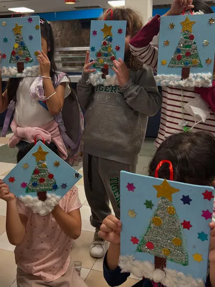 My students hiding behind their glittery Christmas tree creations. So much fun and creativity in one room!