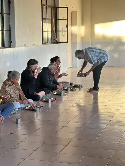 The practice of Karma Yoga, or selfless service. Here, I am serving food to participants during a community meal, an act of love and humility that is central to the yogic path.