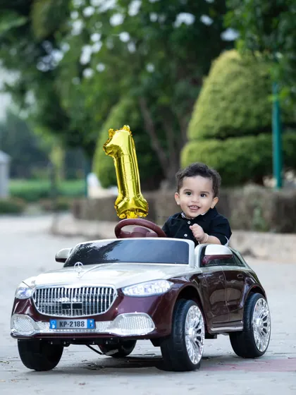 Celebrating his first birthday with a new ride! This little boy is all smiles in his toy car.