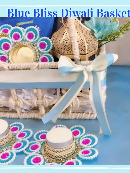 This close-up highlights the handcrafted details of the 'Blue Bliss' basket, from the rope handle to the delicate ribbon and floral diya holders.