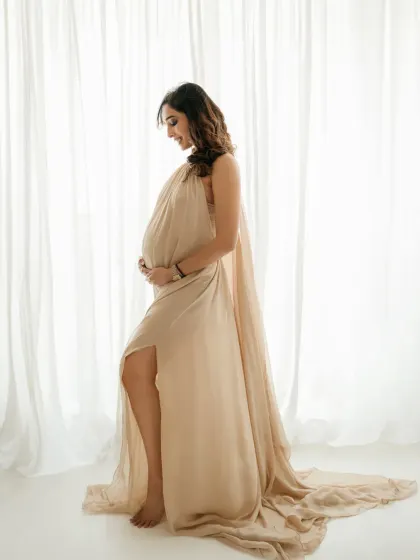 A beautiful silhouette against the soft light from the window. This side profile highlights the baby bump perfectly in a very soft and artistic way.