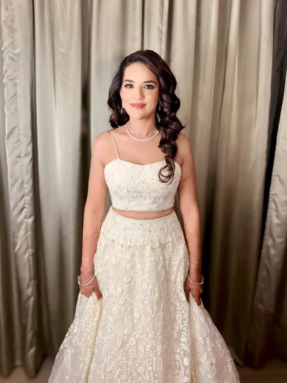 The final sangeet look with side-swept voluminous curls. This hairstyle is perfect for dancing the night away, as it keeps the hair controlled while still looking glamorous and full.