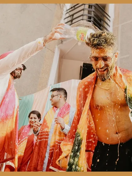 The Haldi fun continues as the groom gets a surprise dousing of cold drink. It's these unpredictable, hilarious moments that make for great memories.