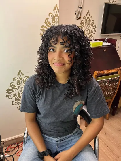 A curl transformation for Brittney, giving her defined curls and face-framing bangs.