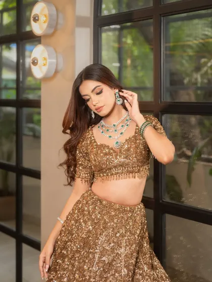 A soft, romantic pose highlights the beautiful flow of the waves and how they frame the face and complement the stunning diamond and emerald jewelry.