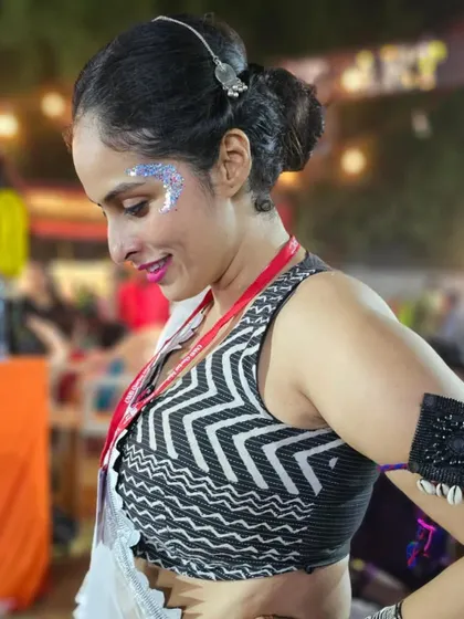 A client smiling with her silver glitter design, ready to hit the Garba dance floor.