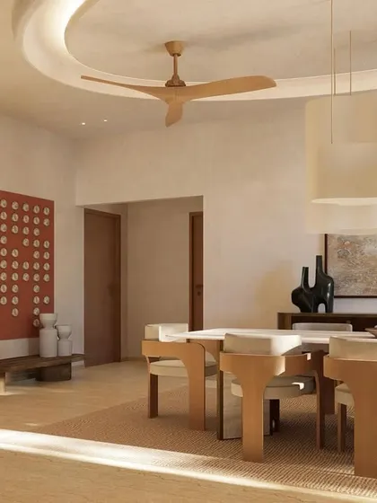 Sunlight filters into the dining space, highlighting the earthy tones and minimal decor. The red art piece adds a deliberate pop of color to the otherwise neutral palette.