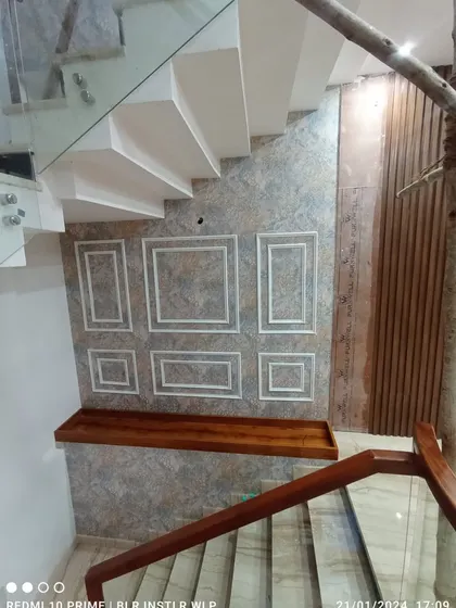 A view from the top of the stairs, showing the paneled wallpaper.