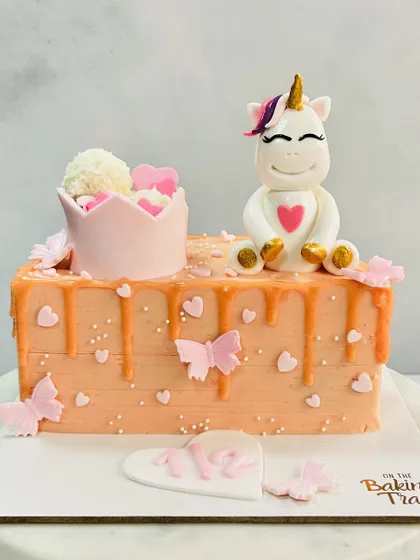 Celebrating a magical half-birthday with this adorable unicorn cake. The design features a cute unicorn, a princess crown, and a soft orange drip.