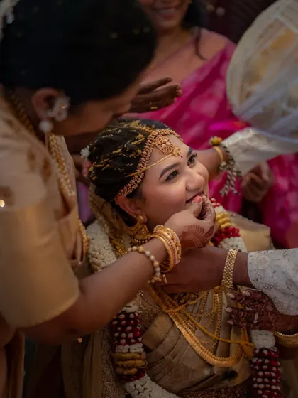 A beautiful, candid moment where the bride is being blessed during the ceremony. Her happy and trusting expression is the heart of this image.