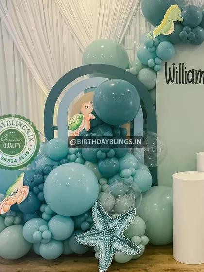 A close-up of an underwater-themed balloon arrangement in shades of teal and seafoam green. The seahorse and starfish details are adorable.