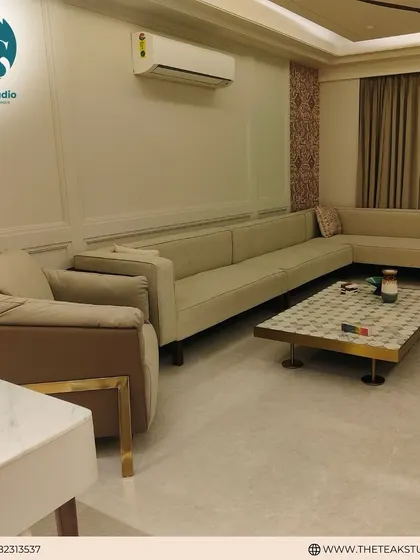 An expansive L-shaped sectional sofa provides ample seating in this luxurious living room. Its neutral color and clean design make it a versatile foundation for the room's decor.