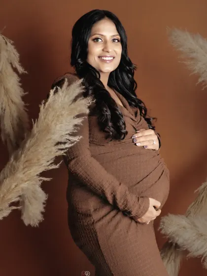 A lovely smile from this glowing mom-to-be. The warm, earthy tones of this boho-inspired studio setup create a relaxed and intimate atmosphere for your maternity portraits.