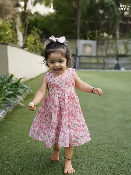 A toddler runs barefoot on the grass, a picture of pure, carefree joy. Outdoor sessions are perfect for capturing this kind of energy.
