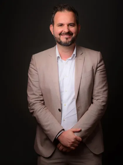 A standing portrait that offers a slightly more relaxed feel than a seated pose, while still maintaining a high level of professionalism.