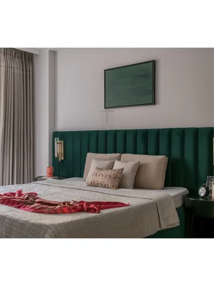 This bedroom is a sanctuary of calm, centered around our custom-made bed with a deep emerald green channel-tufted headboard. The clean lines and rich color create a space of minimalist luxury.
