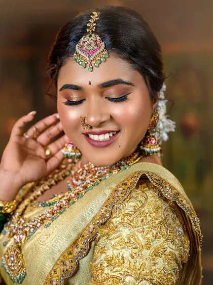 A happy, candid-style shot of the bride. Her smile lights up her face, and the makeup enhances her features without looking heavy.