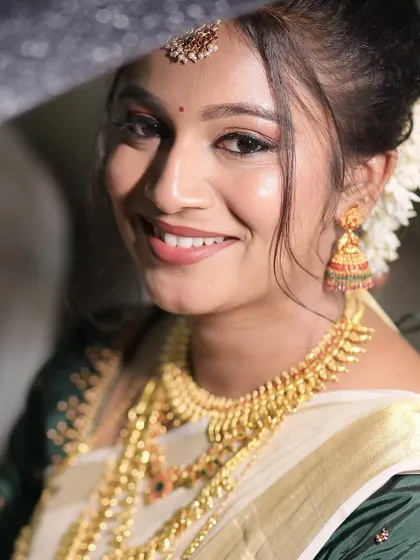 A happy, smiling portrait of the bride. Her makeup enhances her natural beauty and gives her a radiant glow.