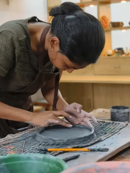 An instructor works on a large hand-built platter, showcasing the advanced skills and techniques that are practiced and taught in our studio every day.