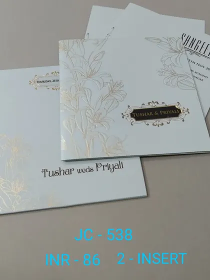 A simple and elegant white invitation with a gold foil lily design. The modern typography and clean layout make it a sophisticated choice for any event.
