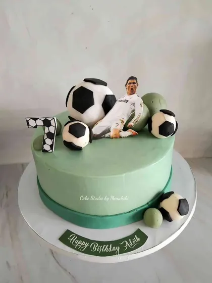 A cake for a young Ronaldo fan turning 7. This design features a CR7 figure, a number 7, and plenty of footballs.