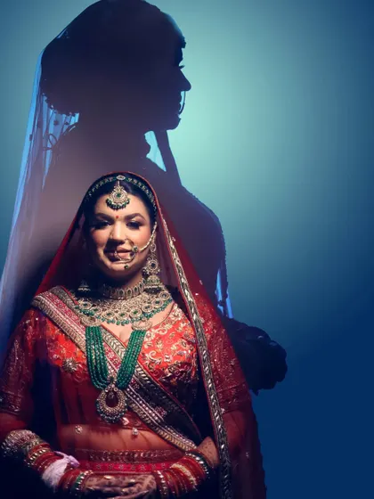 A creative studio portrait of a bride, with her shadow projected behind her, creating an artistic and modern image.