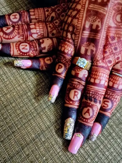 An example of personalized bridal nail art. These extensions feature a glitter accent and the groom's name initialed in the henna design, a special touch I teach for wedding clients.