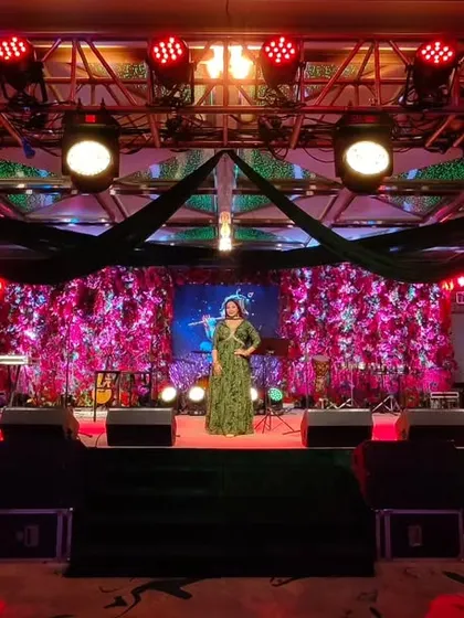 A wide shot of me on a beautifully lit stage. This image showcases not just my presence but also the grand scale and high-quality production of the events I am a part of.