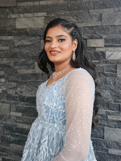 A party-ready look for this client, featuring a shimmery blue dress and boho-inspired hair.