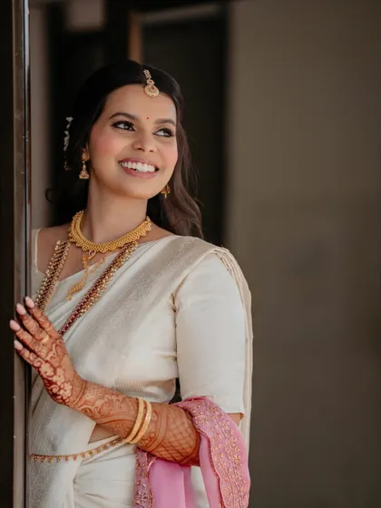 This minimalist South Indian bridal look is all about timeless elegance. The bride's natural beauty is enhanced with a clean base, defined eyes, and a soft lip color.