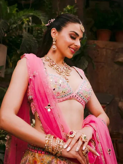 A beautiful Mehendi look with a pink lehenga, featuring soft makeup and a radiant smile.