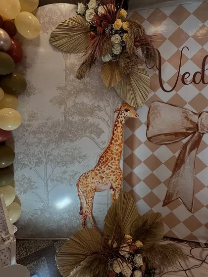 The giraffe cutout and dried palm leaves were key elements in the gentle safari-boho theme. These details, combined with the balloon garland, added texture and visual interest to the decor.