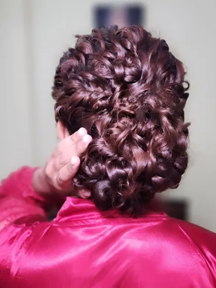 A beautiful close-up of a curly bridal updo. This intricate style keeps the hair off the face while still showcasing the beautiful texture of her curls.