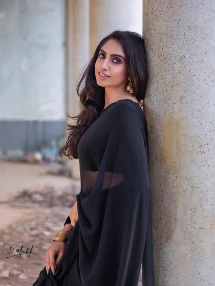 The timeless elegance of a black saree. For this shoot, we used the beautiful texture of old pillars as a backdrop to complement the simple grace of the attire, creating a classic and powerful portrait.